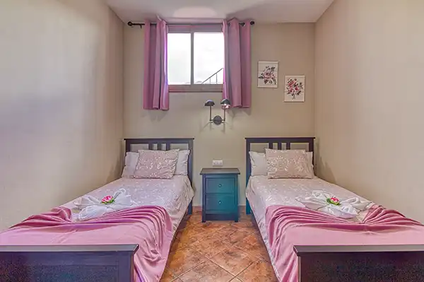 Tercer dormitorio con dos camas individuales y ambiente elegante